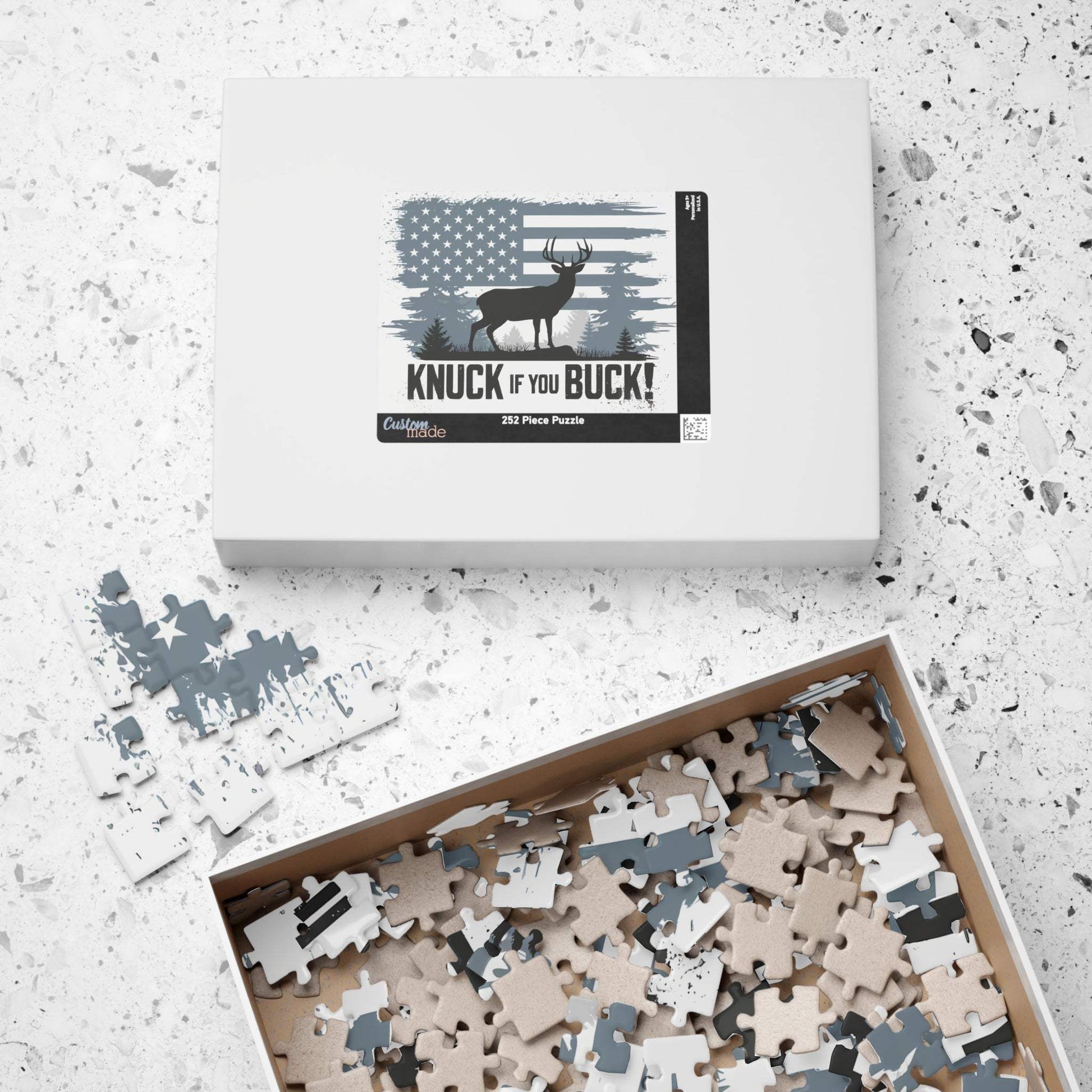 Hunting Themed Puzzle "Knuck If You Buck" design with 252 pieces, box and scattered pieces on a table.